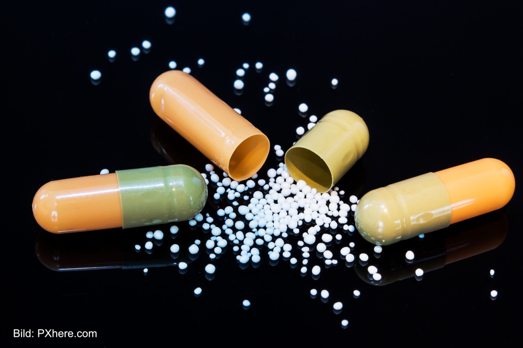 Offene Tabletten. Der Wirkstoff rieselt heraus. Symbolbild für die Arzneitmittelabhaengigkeit von China und Indien.